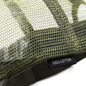 Detail of army green trucker hat breathable mesh structure and 100% cotton wash label