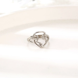 Detailed close-up of silver hollow abstract face ring with minimalist line art style