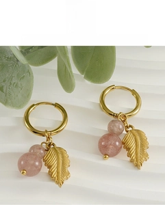 Detail of 18k gold earrings with pink natural stone beads and textured leaf pendant