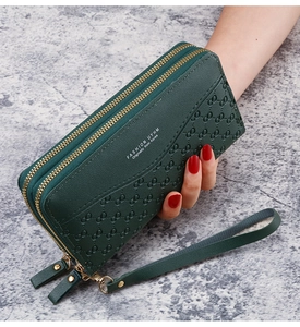 Detail of dark green embossed long wallet with double zipper and detachable wrist strap