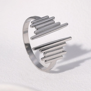 Macro detail of silver wavy open ring showing polished metallic texture and layered design