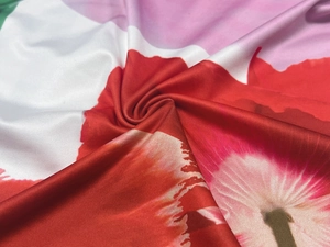 Gros plan sur le tissu à imprimé floral rouge et rose montrant les plis et la texture