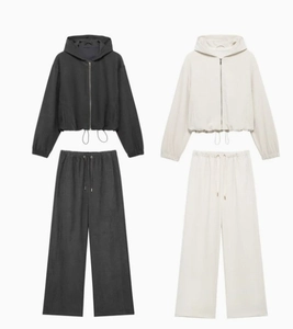 Flat lay of hooded bomber jacket and wide-leg pants in dark grey and off-white set