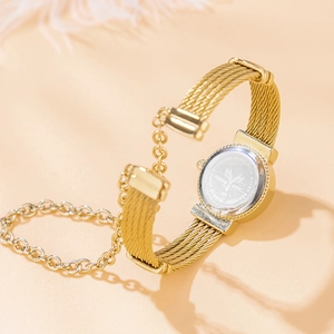 Close-up of gold mesh strap watch with stainless steel back and chain link details