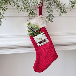 Classic red knitted Christmas stocking with white fleece cuff and XMAS pocket detail