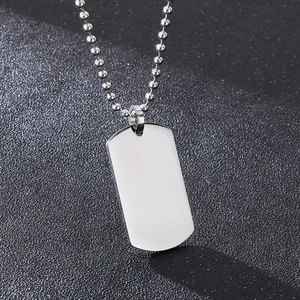 Macro shot of silver rectangular military tag pendant with polished finish and bead chain