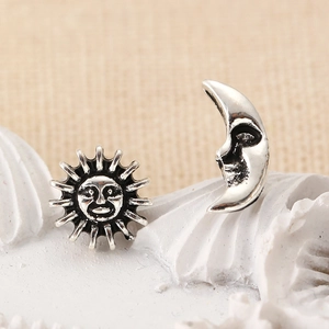 Macro detail of vintage silver earrings featuring sun and moon celestial designs