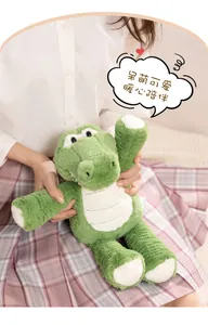 Close-up of a soft green plush crocodile toy being held to show texture and size