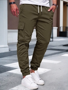 Detail of army green cargo pants featuring multi-pockets and drawstring waist on model