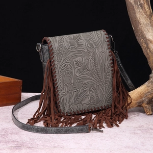 Detailed view of bohemian crossbody bag with floral embossing and decorative brown fringes