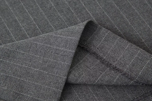 Vue macro détaillée de la texture du tissu gris foncé à rayures et des coutures du pantalon