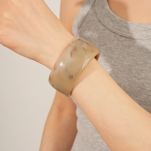 Detail of chunky marble texture resin bangle with beige and brown swirls on wrist