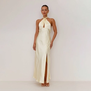 Detail of cross halter neckline and satin fabric on a light yellow sleeveless maxi dress