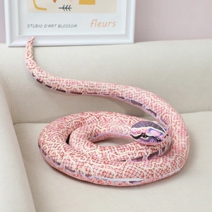 Realistic pink and purple coiled snake plush toy on a soft white sofa in home setting