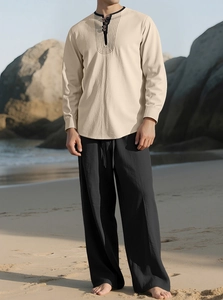 Detail of men's linen beach set featuring beige tunic top and black drawstring trousers