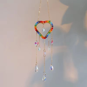 Detail of heart-shaped rainbow suncatcher with colorful beads and crystal prism teardrops