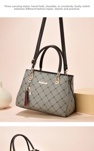 Detail of grey floral tote bag with tassel charm and cat metal accessory on top handles