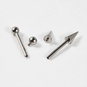 G23 titanium piercing set with silver ball and spike screw attachments on white background