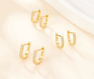 Detail of three pairs of S925 sterling silver U-shaped hoop earrings with gold plating