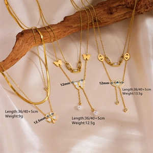 Gold-plated layered necklaces with butterfly, clover and evil eye pendants on silk
