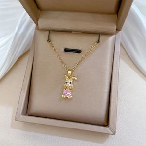 Close-up of gold rabbit necklace with pink zircon in a luxury jewelry box