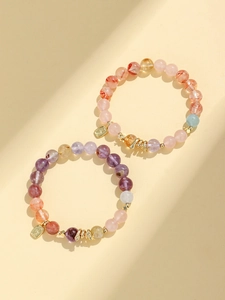 Detail view of purple amethyst and rose quartz beaded bracelets with golden luck charms