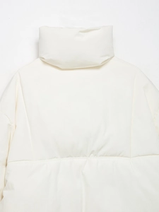 Détail du col montant et du tissu matelassé sur la doudoune beige de style décontracté