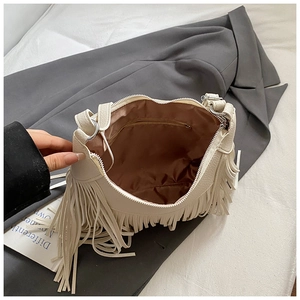 Chic cream leather bucket bag with fringe and zipper interior in high-end photography
