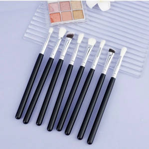 Detail view of 8-piece eye makeup brush set with wooden handles on a purple background