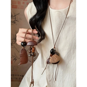 Détail d'un collier vintage en bois avec perles artisanales sur vêtement en lin