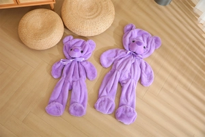 Detailed view of empty purple teddy bear skins in two sizes on wooden floor