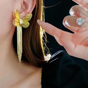 Detail von 18K vergoldetem Schmetterlings-Ohrring mit Quasten am Model