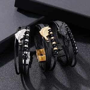 Detailed view of multilayer leather bracelets with feather charms and stainless steel beads