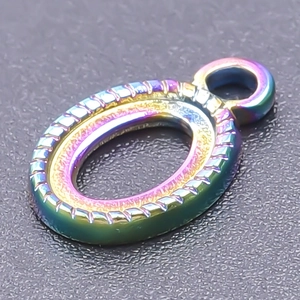 Macro view of rainbow stainless steel oval pendant with textured edges and a top loop