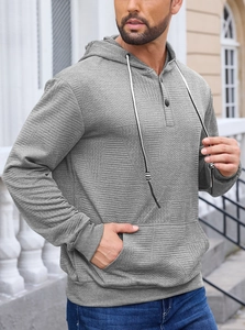 Detail of grey men's hoodie showing textured jacquard fabric and buttoned neckline