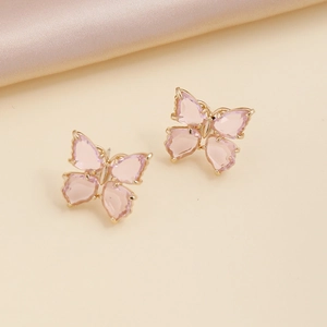 Exquisite golden butterfly stud earrings with pink zircon crystals on silk fabric