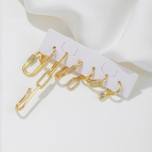 6-piece gold geometric earring set with micro-paved zircons on elegant silk background