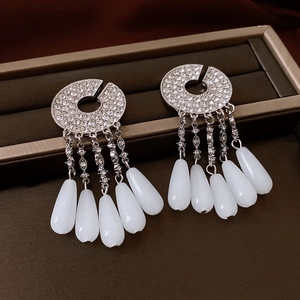 Detail of silver drop tassel earrings with rhinestones in a brown jewelry gift box