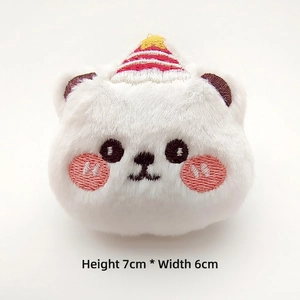 Detailed view of plush white bear head accessory with birthday hat and 7x6cm dimensions