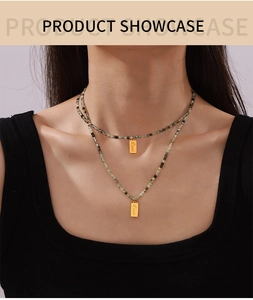 Detail view of double-layer bohemian necklace with green stone beads and Love pendant