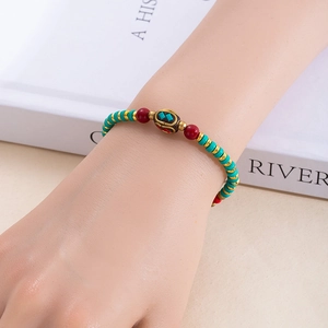 Gros plan d'un bracelet de perles bohème avec turquoise et breloques ethniques au poignet