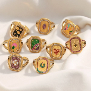 Bagues tarot plaquées or 18 carats avec motifs cœur et trèfle sur tissu blanc