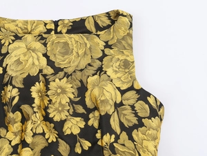 Primer plano detallado de la tela de brocado floral dorado y cremallera en el vestido negro