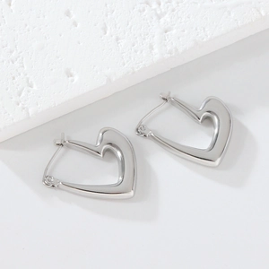 Vue rapprochée des boucles d'oreilles cœur en argent avec une finition polie miroir