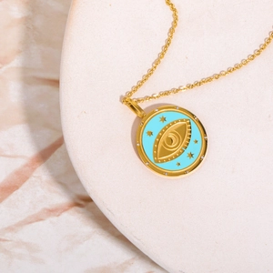 Detail of gold evil eye tarot necklace with turquoise enamel and small crystals