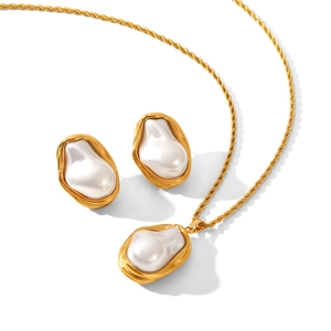 Elegant gold stainless steel necklace and baroque pearl earrings on a white background