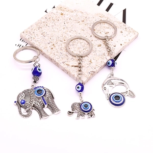 Detailed view of tribal style elephant and dolphin evil eye charms in antique silver