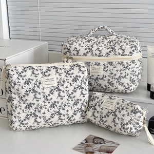 Three-piece floral quilted cotton bags including tote and pouches on a sunny window