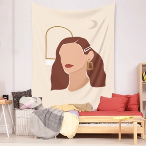 Detail of bohemian tapestry featuring abstract female silhouettes and golden moon symbols