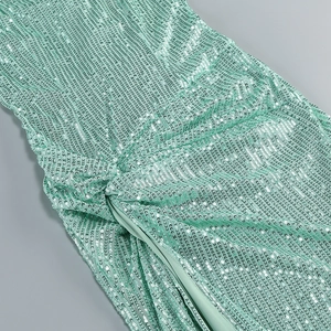 Detail of mint green sequin dress showing pleated texture and elegant side slit design